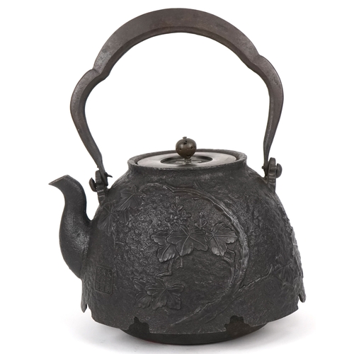  A Japanese cast iron teapot, 19th century, decorated with a phoenix bearing a nine character mark to... 