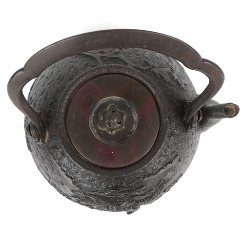  A Japanese cast iron teapot, 19th century, decorated with a phoenix bearing a nine character mark to... 