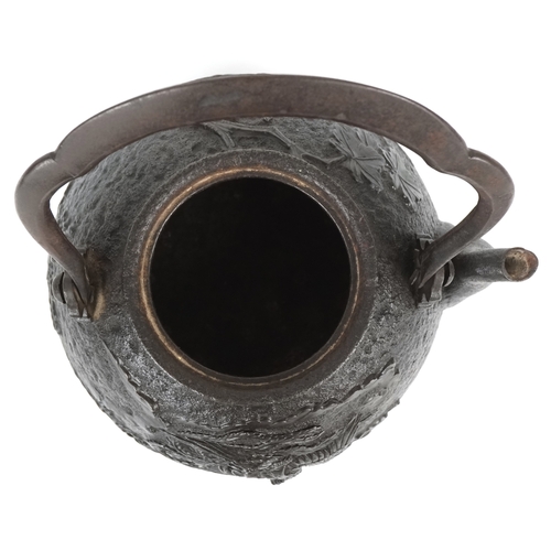  A Japanese cast iron teapot, 19th century, decorated with a phoenix bearing a nine character mark to... 
