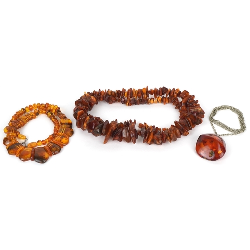 3518 - Two amber coloured bead necklaces together with a similar pendant on a white metal necklace, the lar... 