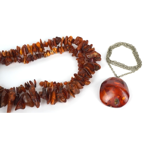 3518 - Two amber coloured bead necklaces together with a similar pendant on a white metal necklace, the lar... 
