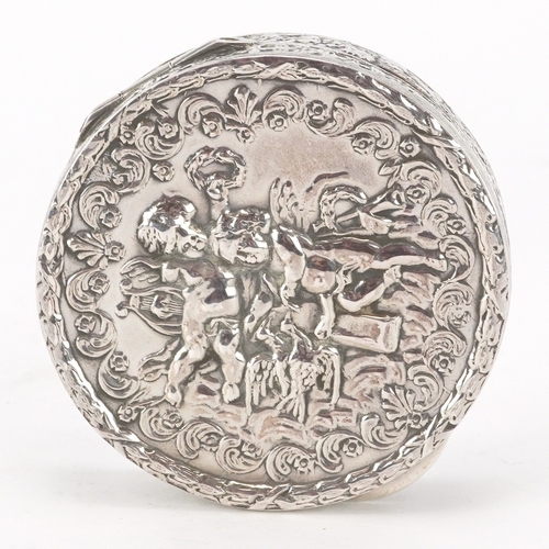 52 - A silver circular snuff box embossed with Putti, London import marks 1976, 5.3cm in diameter, 35.8g.