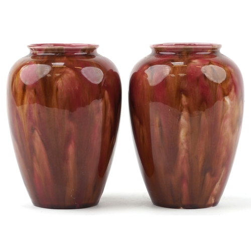 1656 - A pair of early 20th century Wardle pottery vases, each with a red and pink abstract glaze, bearing ... 