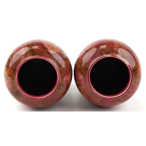 1656 - A pair of early 20th century Wardle pottery vases, each with a red and pink abstract glaze, bearing ... 
