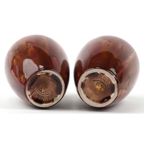 1656 - A pair of early 20th century Wardle pottery vases, each with a red and pink abstract glaze, bearing ... 