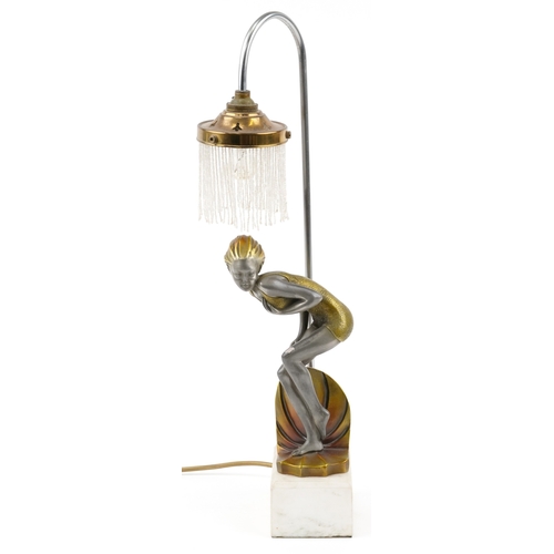 210 - An Art Deco style table lamp in the form of a female figure raised on a marble base, 52cm high.