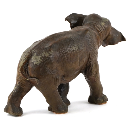 479 - An early 20th century Tole painted spelter model of a standing elephant, 33cm high x 55cm wide.