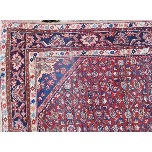 2220 - A Persian Sarouk gallery runner, 20th century, the red field with an allover flower head design with... 