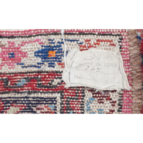 2220 - A Persian Sarouk gallery runner, 20th century, the red field with an allover flower head design with... 