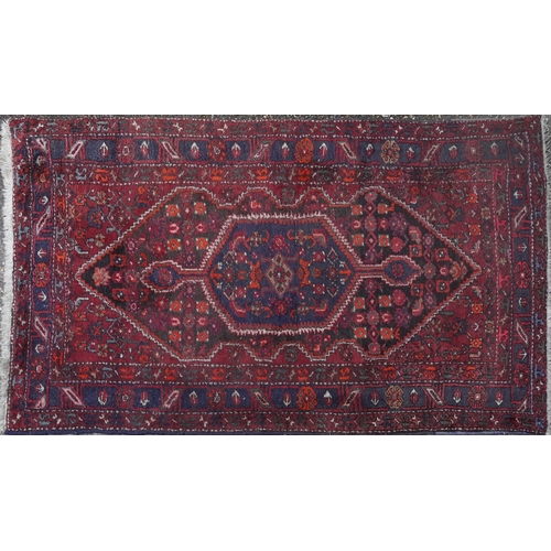 2221 - A Hamadan rug, North West Persia, mid 20th century, the red field with a stylized central medallion ... 