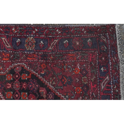 2221 - A Hamadan rug, North West Persia, mid 20th century, the red field with a stylized central medallion ... 