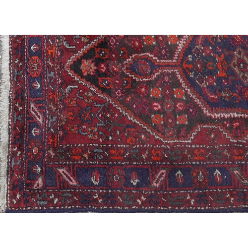 2221 - A Hamadan rug, North West Persia, mid 20th century, the red field with a stylized central medallion ... 