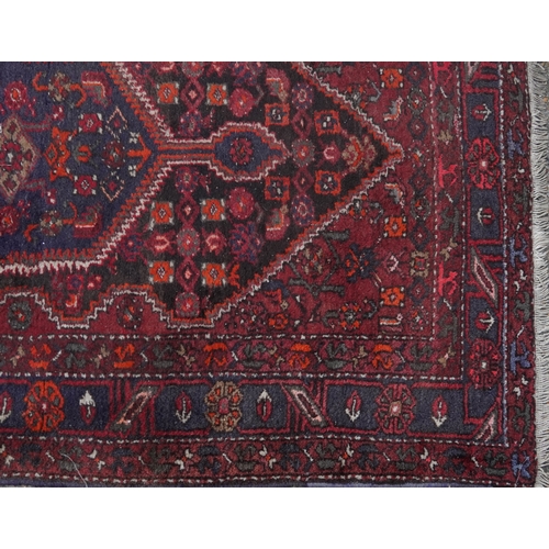 2221 - A Hamadan rug, North West Persia, mid 20th century, the red field with a stylized central medallion ... 