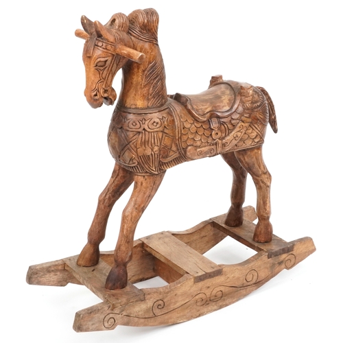 697 - An Eastern carved hardwood rocking horse, 91cm H x 96cm W x 31cm D.