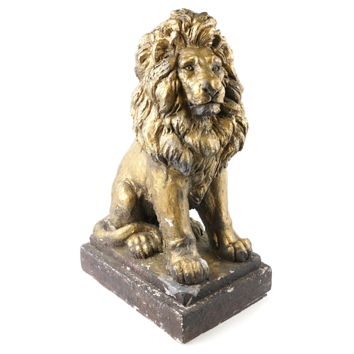 473 - A large painted plaster sculpture of a seated lion raised on a plinth base, 66cm high.