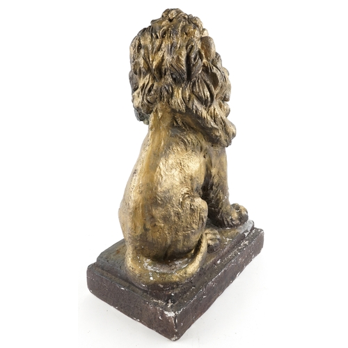 473 - A large painted plaster sculpture of a seated lion raised on a plinth base, 66cm high.