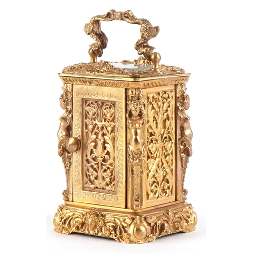 131 - A miniature gilt brass Rococo style carriage clock with swing handle, the dial having Roman numerals... 