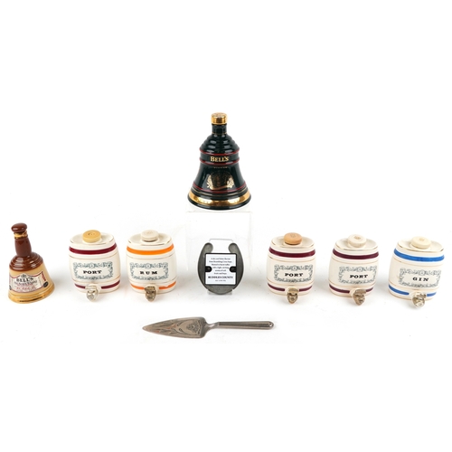 673 - Seven Wade porcelain decanters and a silver plated cake slice, the largest 19cm high.