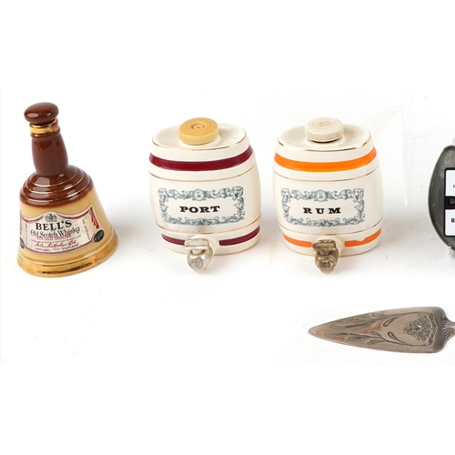 673 - Seven Wade porcelain decanters and a silver plated cake slice, the largest 19cm high.