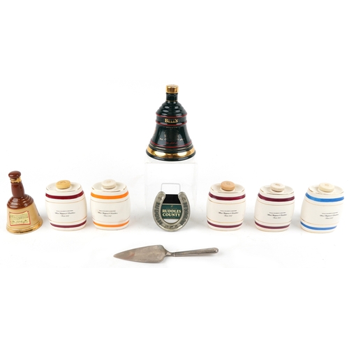 673 - Seven Wade porcelain decanters and a silver plated cake slice, the largest 19cm high.