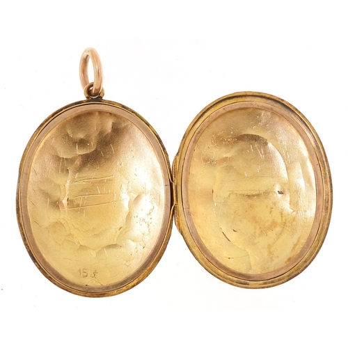 3020 - A Victorian 15ct gold locket finely engraved with foliage and an eternity belt, 3.7cm high, 9.9g.