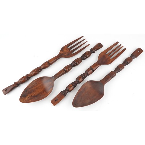 1805 - Four large carved softwood decorative forks and spoons, 69cm in length.
