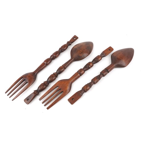 1805 - Four large carved softwood decorative forks and spoons, 69cm in length.