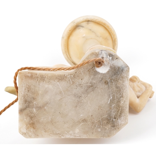 110 - An early 20th century carved alabaster table lamp base modelled as a reclining female nude together ... 