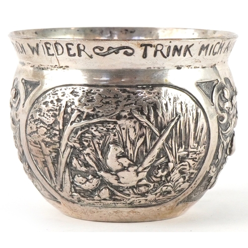 3716 - A German silver cup decorated with panels embossed with birds and foliage, inscribed 'Drink me up an... 