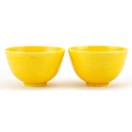 1596 - A pair of Chinese yellow glazed porcelain bowls with incised dragons, six figure character marks to ... 