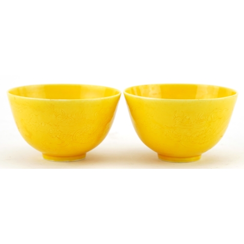 1596 - A pair of Chinese yellow glazed porcelain bowls with incised dragons, six figure character marks to ... 