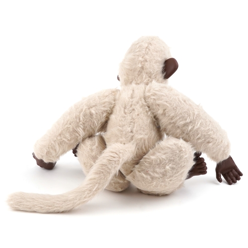 739 - A stuffed mohair toy monkey with articulated limbs and moving eyes, 45cm high.