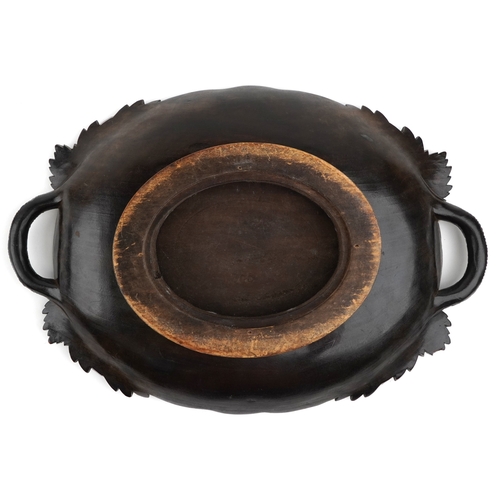1884 - An early 20th century beech oval centrepiece bowl carved with leaves, with pierced handles, 9cm high... 