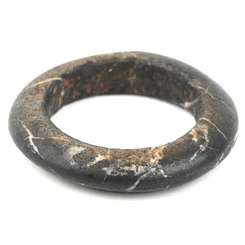1684 - A carved stone bangle, possibly African Dogon tribe, 10cm in diameter together with a stone fragment... 