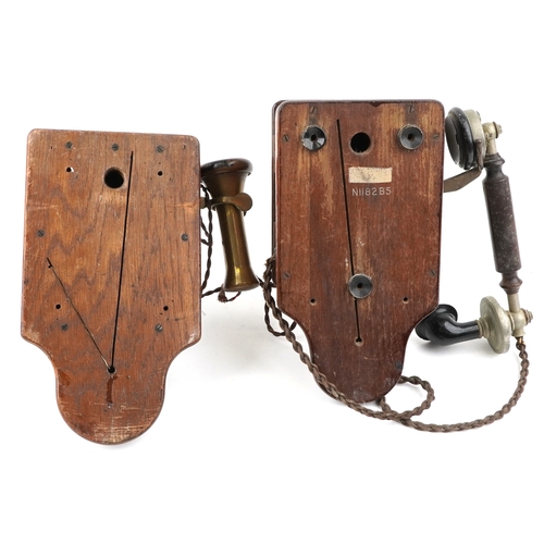 572 - Two similar early 20th century oak cased wall mounted telephones, each with brass receivers, the dia... 