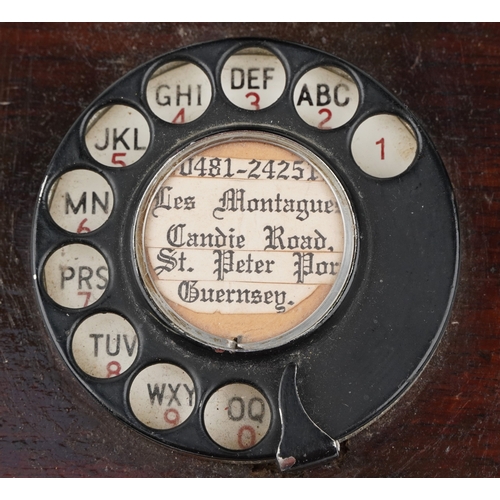 572 - Two similar early 20th century oak cased wall mounted telephones, each with brass receivers, the dia... 