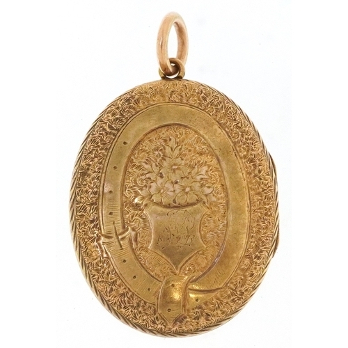 3020 - A Victorian 15ct gold locket finely engraved with foliage and an eternity belt, 3.7cm high, 9.9g.
