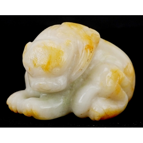 1486 - A Chinese carved celadon and russet jade temple dog, 4cm wide.