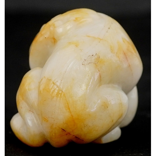 1486 - A Chinese carved celadon and russet jade temple dog, 4cm wide.