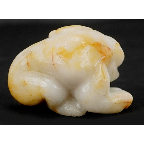 1486 - A Chinese carved celadon and russet jade temple dog, 4cm wide.