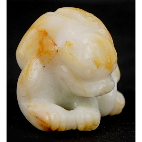 1486 - A Chinese carved celadon and russet jade temple dog, 4cm wide.