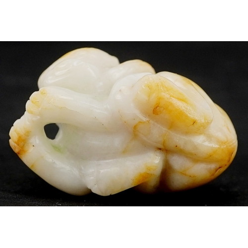 1486 - A Chinese carved celadon and russet jade temple dog, 4cm wide.