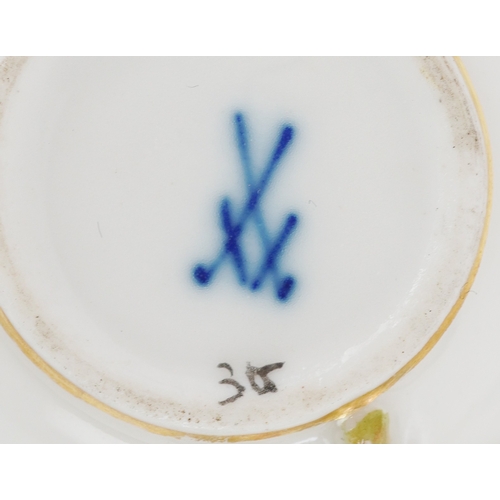 34 - A Meissen porcelain cup and saucer decorated with flowers together with a similar diminutive cup and... 