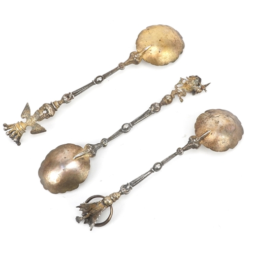 3656 - A set of three silver gilt souvenir spoons with masked bowls and figural finials including a dragon,... 