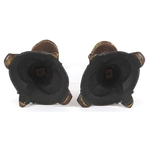 495 - A pair of gilt metal candlesticks with cast leaf decoration, 23cm high.