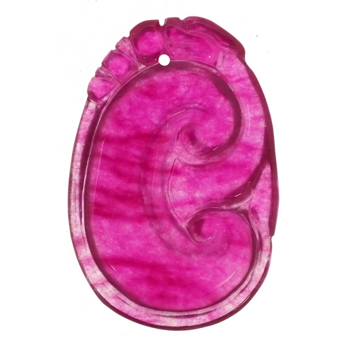 1499 - A Chinese carved pink stone pendant, tests as jade, 4cm high, 12.4g.