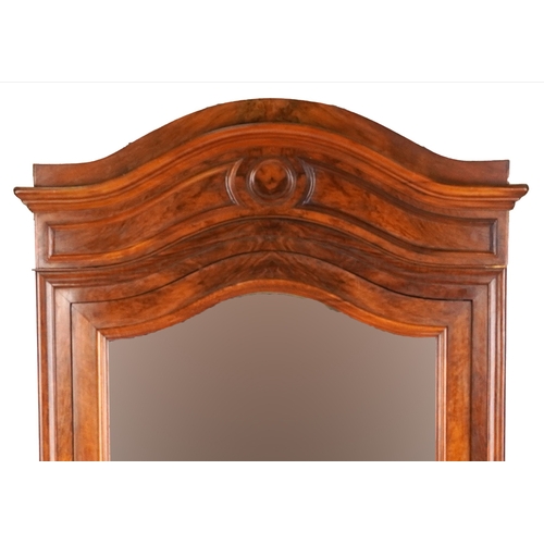 2002 - A 19th century walnut armoire, the arched pediment above a mirrored panel door, the base fitted with... 