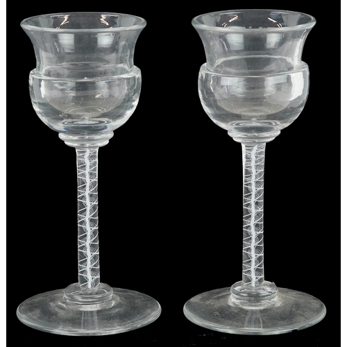 44 - A near pair of 18th century air twist stem glasses, each 13.5cm high.