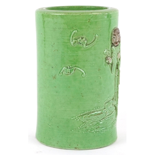 458 - A Chinese porcelain green ground brush pot decorated in relief with an elder and fruit bats, 15cm hi... 