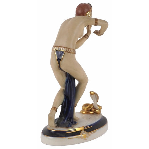 487 - A Royal Dux Czechoslovakian porcelain figure of a snake charmer, 24cm high.
